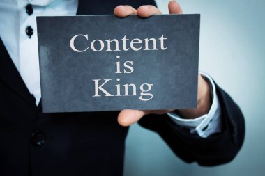 Kelime içeriği gösteren işadamı bir karton üzerinde kraldır.