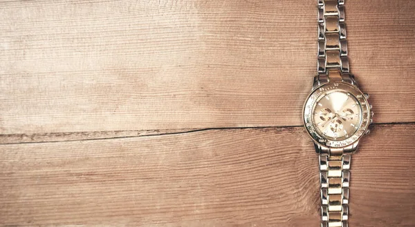 Ρολόι χεριού σε ένα ξύλο παρασκήνιο. — Φωτογραφία Αρχείου