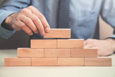 Tahta blokları istifleyen adam. Geliştirme kavramı.