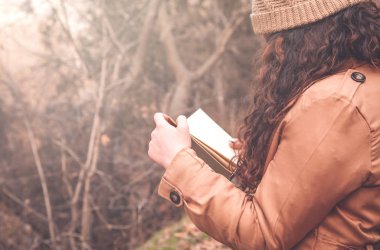 Kız okuma kitabı sonbahar parkta.