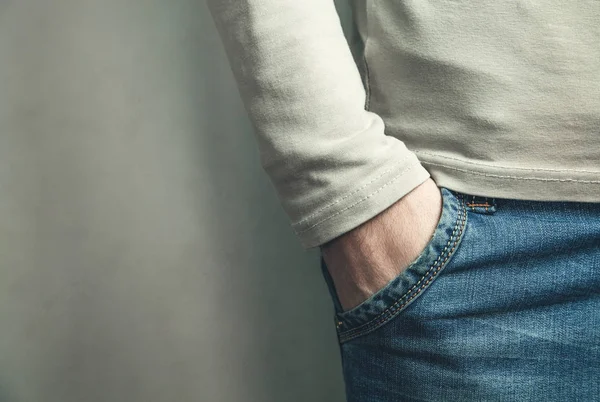 Man with his hand in jeans pocket.