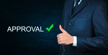 Dağ eteğindeki taş yığını üzerinde bir başparmak yukarıya kelime onay işaretiyle gösterilen işadamı