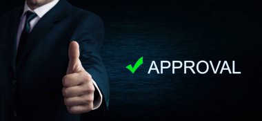 Dağ eteğindeki taş yığını üzerinde bir başparmak yukarıya kelime onay işaretiyle gösterilen işadamı