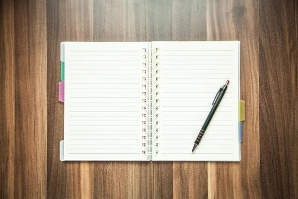 Stift und Notizblock auf Holz-Hintergrund. — Stockfoto