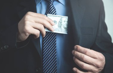 100 dolarlık takım elbise cebine koyarak işadamı.