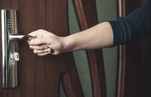 Main tenant une poignée métallique dans la porte . — Photo