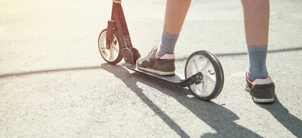 Jongen op een scooter rijden op straat. — Stockfoto