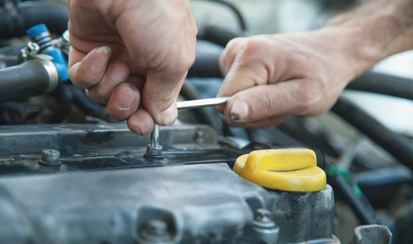 Wrench in hand. Man working in repair service and fixing car eng — Stock Photo, Image