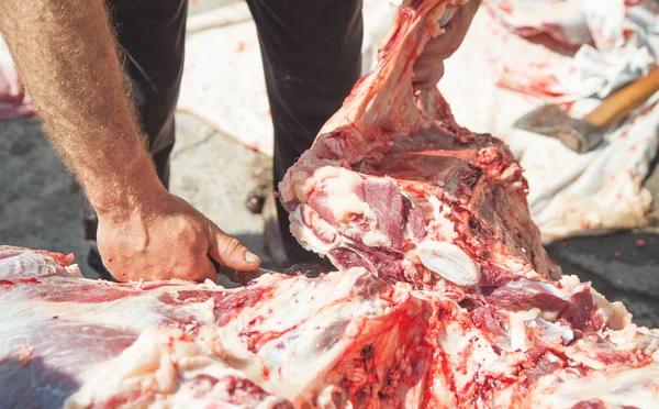 Procesando carne fresca. Carnicero con un cuchillo en la mano que separa m — Foto de Stock