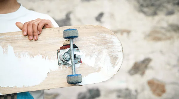 Kaukasischer Junge mit Skateboard in der Hand. — Stockfoto