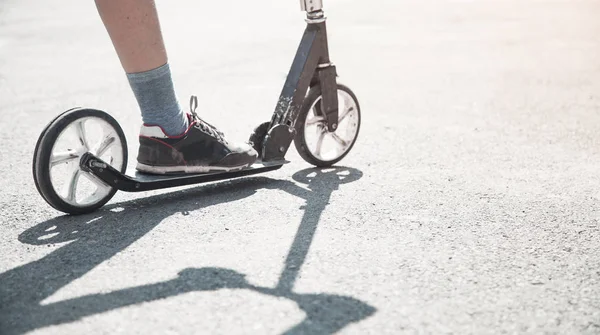 Pojke på skoter rider på gatan. — Stockfoto