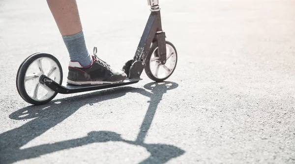 Jongen op een scooter rijden op straat. — Stockfoto