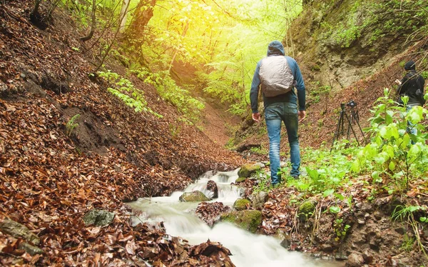 Mann geht im Wald spazieren. Wasserfluss im Wald — Stockfoto