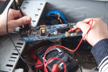 Adam bir multimetre ile bilgisayar kontrol.