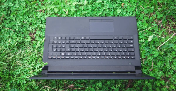 Black laptop with blank screen on grass. — Stock Photo, Image