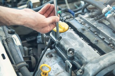 Araba motorunda çalışan tamirci. Oto tamir, Servis merkezi