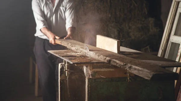 Menuisier découpant une planche de bois avec une menuiserie. — Photo