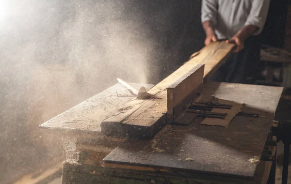 Tesař řeže dřevěné prkno s tesařským strojem. — Stock fotografie