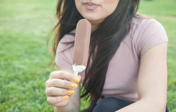 Piękna kobieta jedzenie lodów w parku. — Zdjęcie stockowe