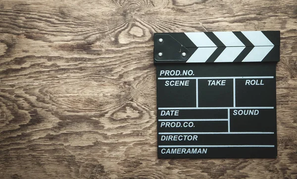 Film clapper op houten achtergrond. — Stockfoto