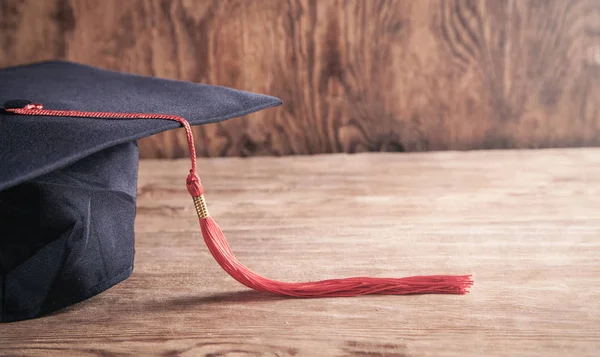 毕业帽在木制桌子上.教育 — 图库照片