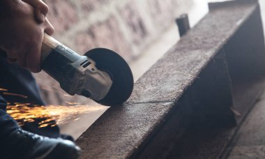 Adam metali öğütücüyle keser. Endüstriyel konsept