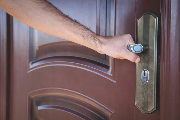 Hand holding a metal handle in the door. — Stock Photo, Image
