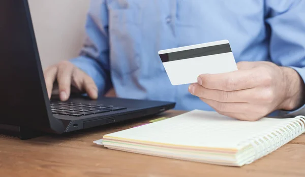 Man holding credit card and using laptop. Online payment and shopping