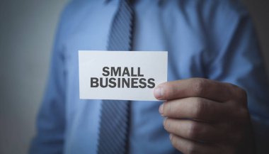 Elinde küçük işletme kartı olan bir adam.