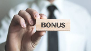 Bonus metin ile tahta blok tutan adam.