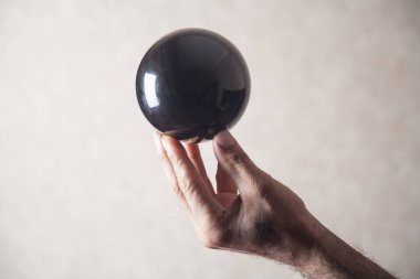 Siyah kristal küre tutan adam.