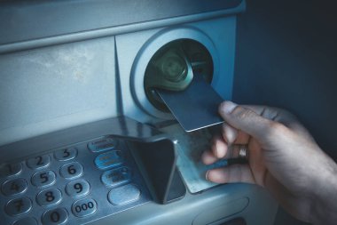 Kredi kartı olan bir adamın eli. ATM 'de. Parayı çek.