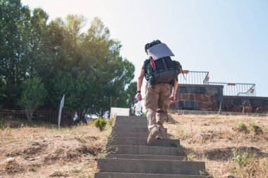Sırt çantalı bir turist merdivenlerden çıkıyor..