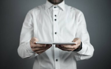 Beyaz dijital tablet tutan bir işadamı. 