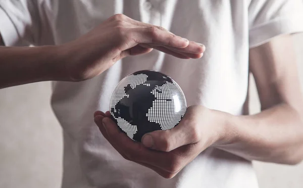 Man protect world map on black crystal ball.