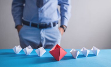 Ofisteki iş adamı. Beyaz tekneli kırmızı origami kağıt tekne. İş, Liderlik