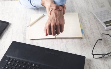 Ofiste bilek ağrısı çeken beyaz bir işadamı.. 