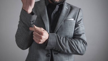 Ofiste gömlek ve ceket giyen bir iş adamı duruyor..