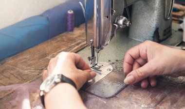 Kafkasyalı terzi dikiş makinesiyle çalışıyor..