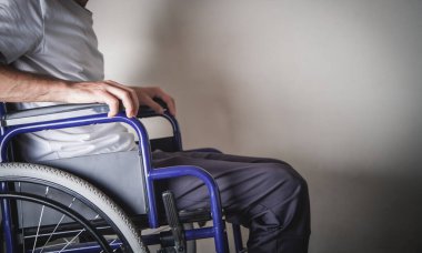 Evde tekerlekli sandalyede sakat bir adam var..
