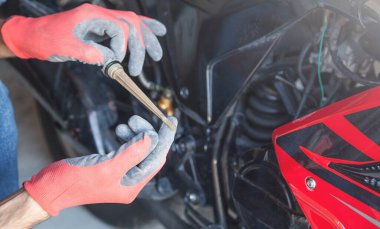 Tamirci motor yağı seviyesini kontrol ediyor..