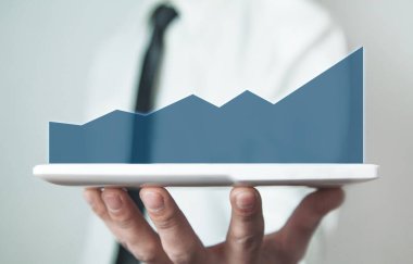 Elinde iş grafiği olan bir tablet tutan adam. İş konsepti