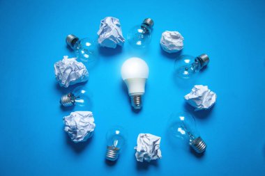 Ampuller ve buruşuk kağıtlar mavi arkaplanda. Fikir.