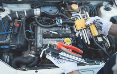 Tamirhanede çalışan bir tamirci. Aletlerin elleri