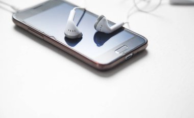 Kulaklık ve akıllı telefon ofis masasında..