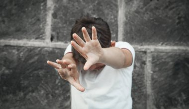 Beyaz çocuk dur işareti gösteriyor..