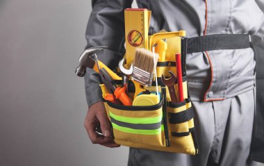 Alet kemeri olan bir işçi. Yapı araçları