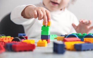 Renkli plastik bloklarla oynayan küçük kız.