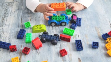 Renkli plastik bloklarla oynayan küçük kız.