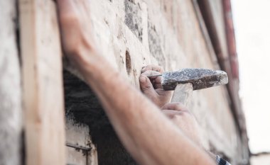 Tahtaya çivi çakan bir adam..